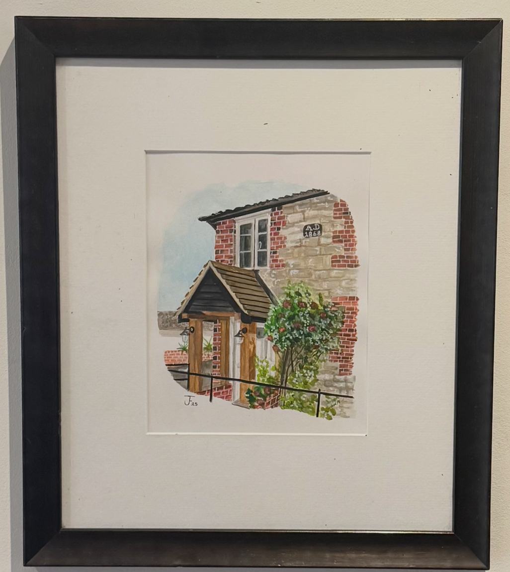 Framed watercolour house portrait of a red-brick cottage, hung on a wall