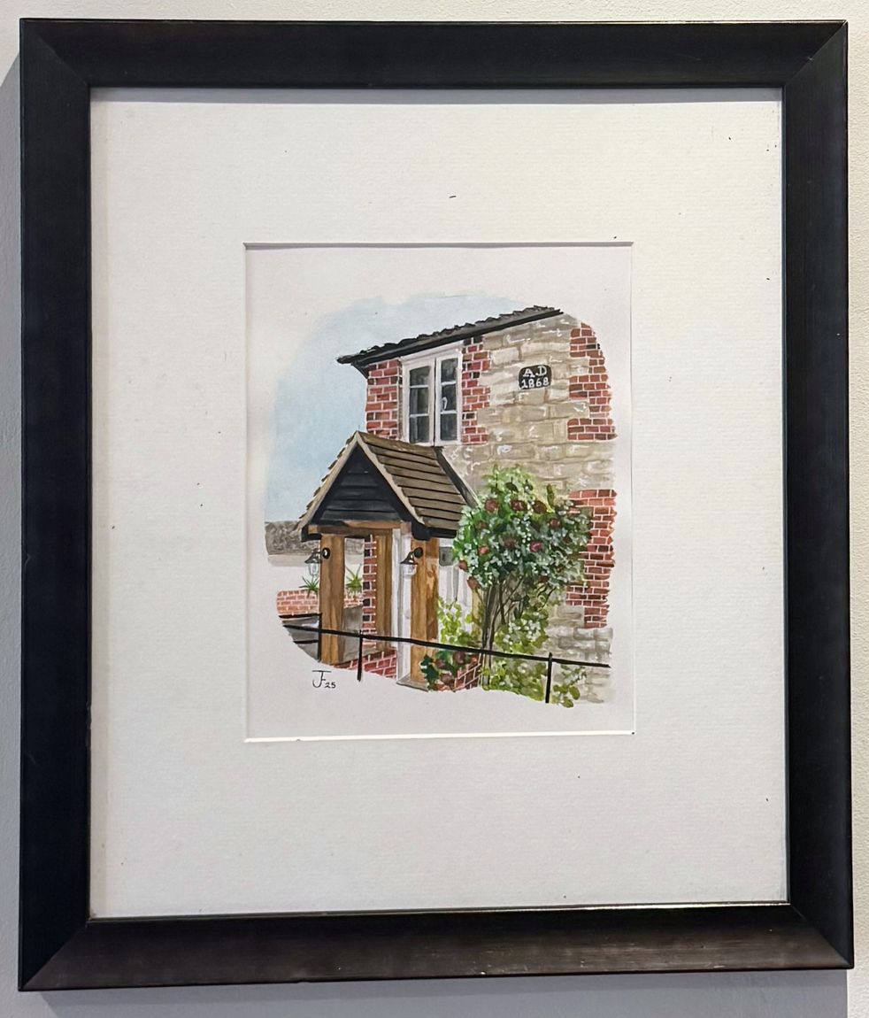 Framed watercolour house portrait of a red-brick cottage, hung on a wall